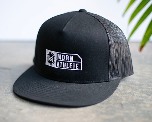 A black snapback hat with custom white embroidery