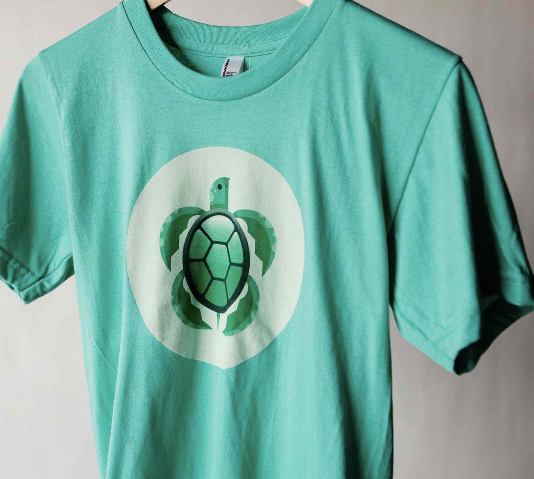 An eco-friendly green shirt with a cute little turtle on the front, printed with water based inks