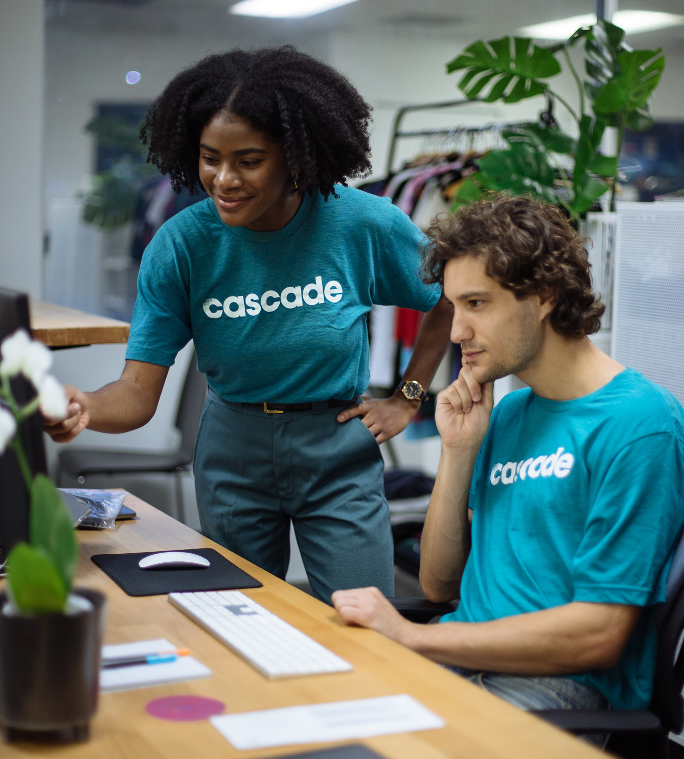A woman helps a man understand a work project