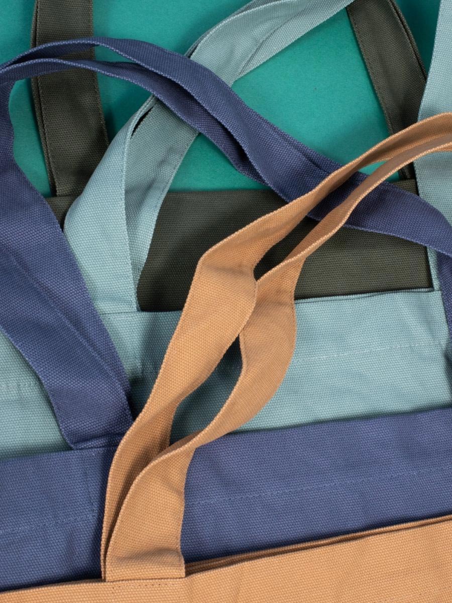 A stack of tote bags in neutral tones