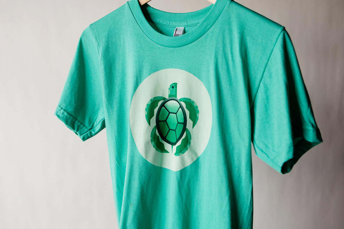 Green hanging t-shirt with green turtle logo on the front
