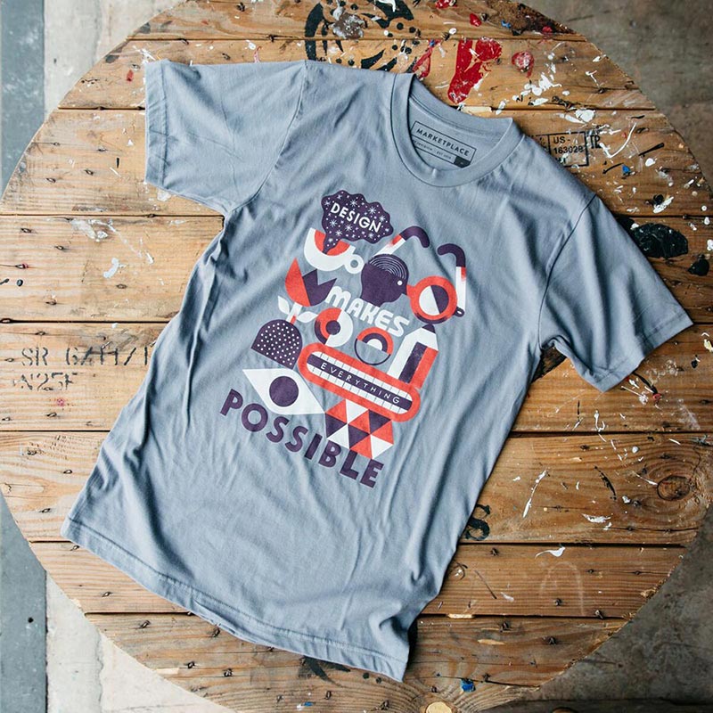 Light blue shirt with multiple red, white and blue designs on a wooden table