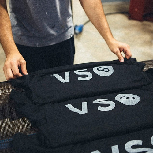 man taking shirts off of dryer