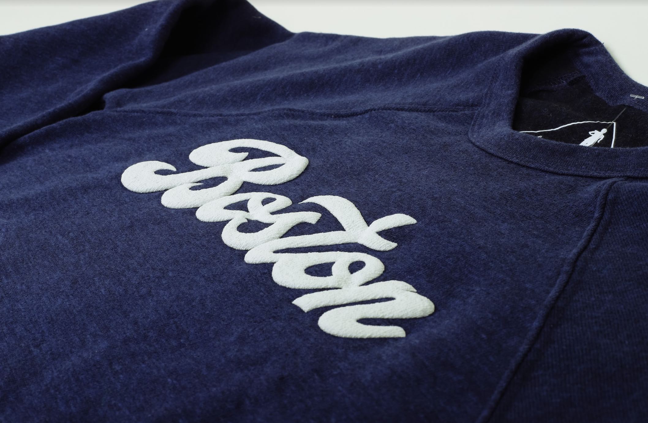 Puff ink spells out "BOSTON" on a sweatshirt.